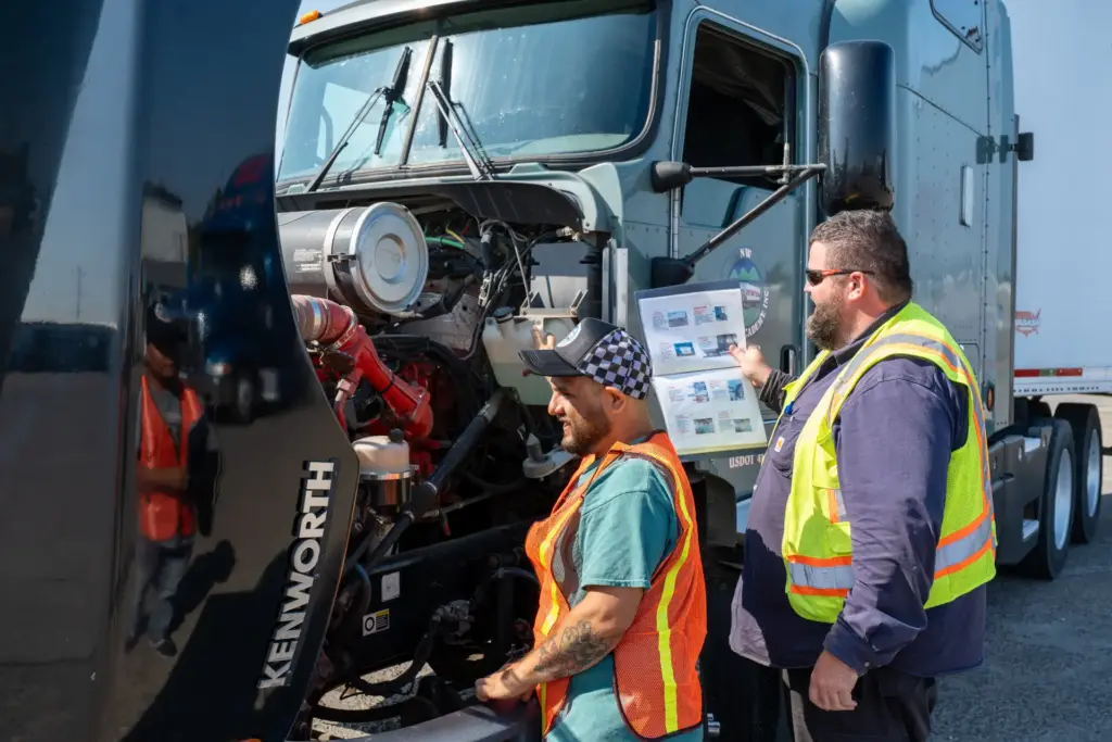 Instructor walking a student through a pre-trip engine inspection