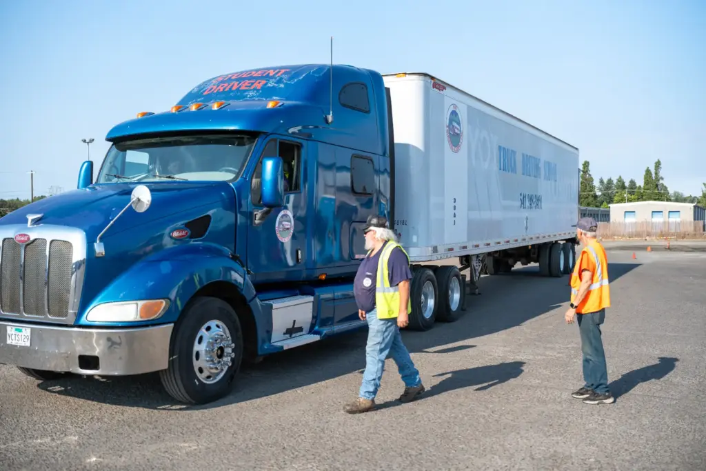 NW Trucking Academy instructor and student walking past a training truck